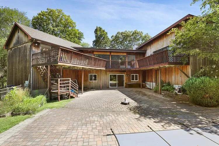 Back of property with a patio area, stairs, a deck, and decorative driveway Back of property with a patio area, stairs, a deck, and decorative driveway
