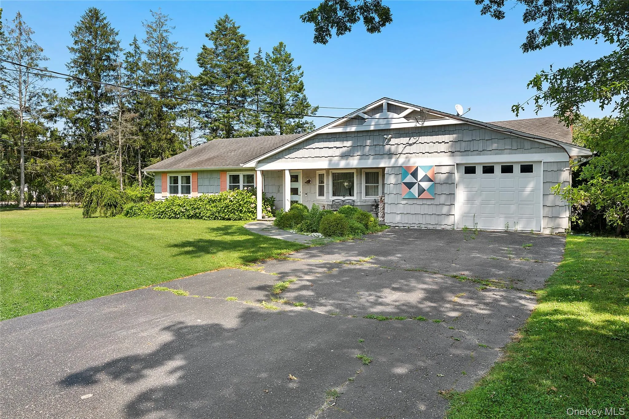 View of front of property featuring driveway, a garage, a front yard, and a shingled roof View of front of property featuring driveway, a garage, a front yard, and a shingled roof