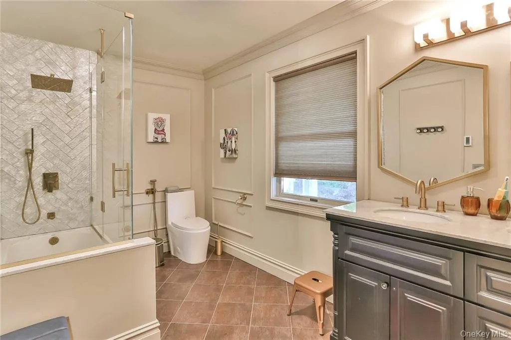 Full bath with vanity, ornamental molding, and tile patterned floors Full bath with vanity, ornamental molding, and tile patterned floors