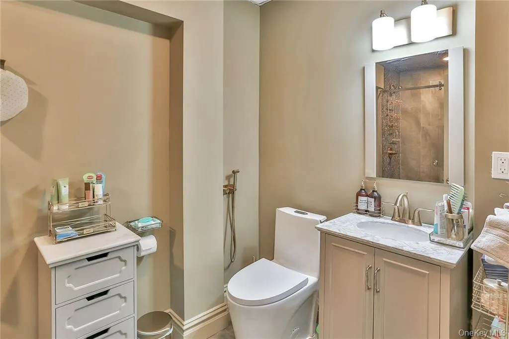 Lower level full bath featuring tiled shower and vanity Lower level full bath featuring tiled shower and vanity