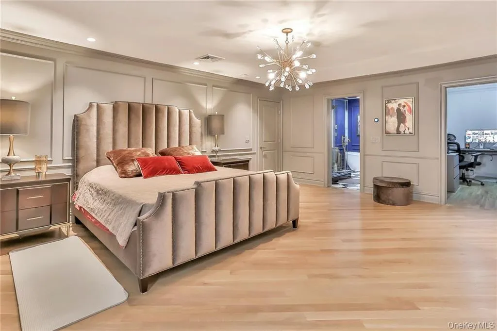 Bedroom featuring a decorative wall, a chandelier, light wood-type flooring, and recessed lighting Bedroom featuring a decorative wall, a chandelier, light wood-type flooring, and recessed lighting