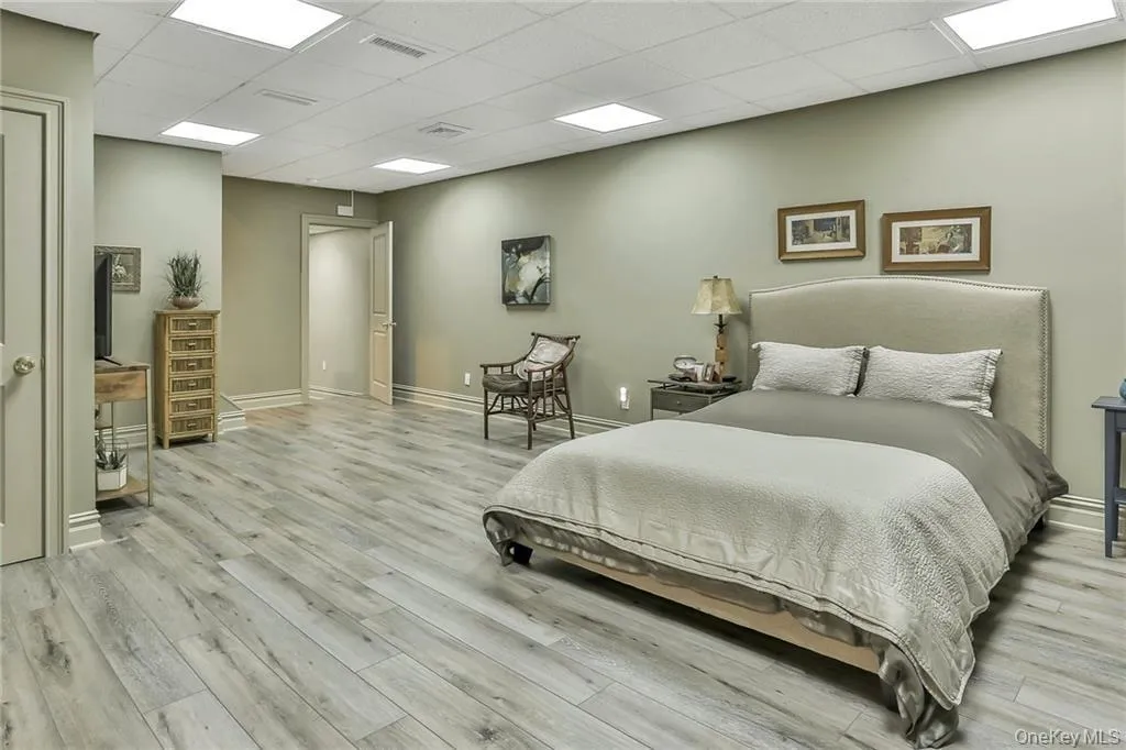 Lower level bedroom with a paneled ceiling and light wood-type flooring Lower level bedroom with a paneled ceiling and light wood-type flooring