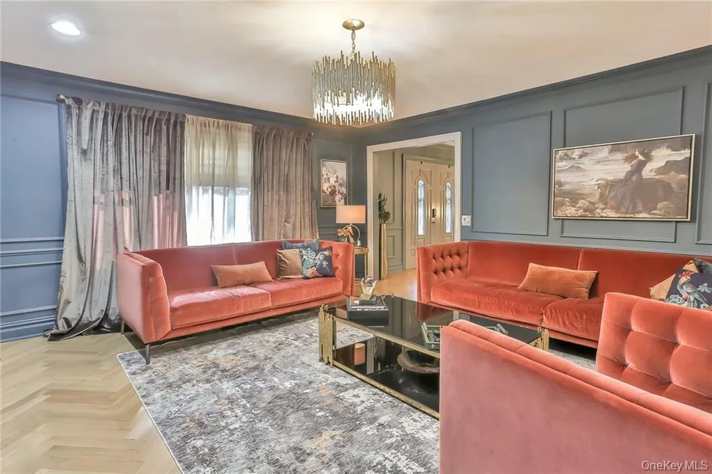 Living room featuring a decorative wall and a chandelier Living room featuring a decorative wall and a chandelier