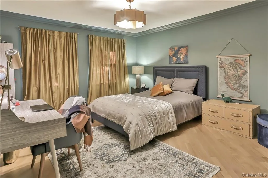 Bedroom featuring crown molding and wood finished floors Bedroom featuring crown molding and wood finished floors