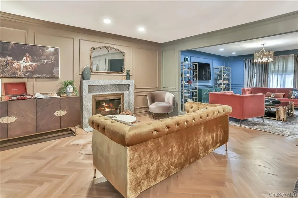 Living room featuring a decorative wall, recessed lighting, a fireplace, and a chandelier Living room featuring a decorative wall, recessed lighting, a fireplace, and a chandelier