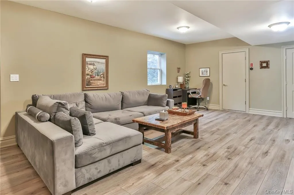 Lower level living room featuring light wood-style floors and a desk Lower level living room featuring light wood-style floors and a desk