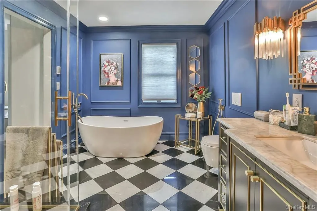 Bathroom with a decorative wall, vanity, a freestanding bath, and tile patterned floors Bathroom with a decorative wall, vanity, a freestanding bath, and tile patterned floors