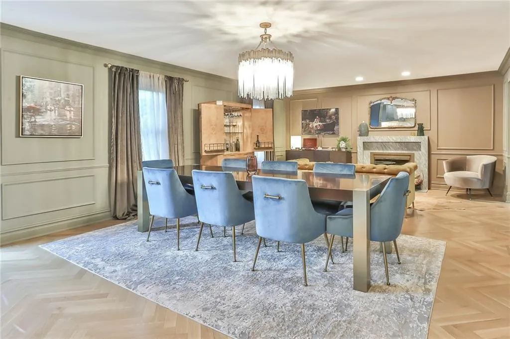 Dining area featuring a decorative wall, a chandelier, a premium fireplace, recessed lighting, and ornamental molding Dining area featuring a decorative wall, a chandelier, a premium fireplace, recessed lighting, and ornamental molding