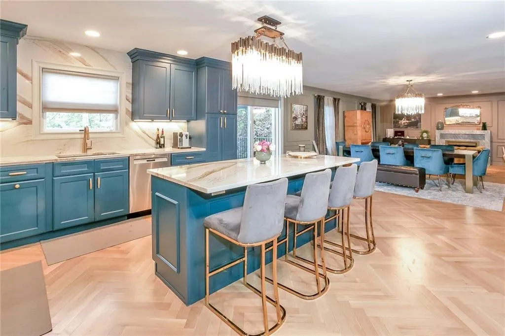 Kitchen featuring a chandelier, a kitchen breakfast bar, blue cabinets, recessed lighting, and stainless steel dishwasher Kitchen featuring a chandelier, a kitchen breakfast bar, blue cabinets, recessed lighting, and stainless steel dishwasher