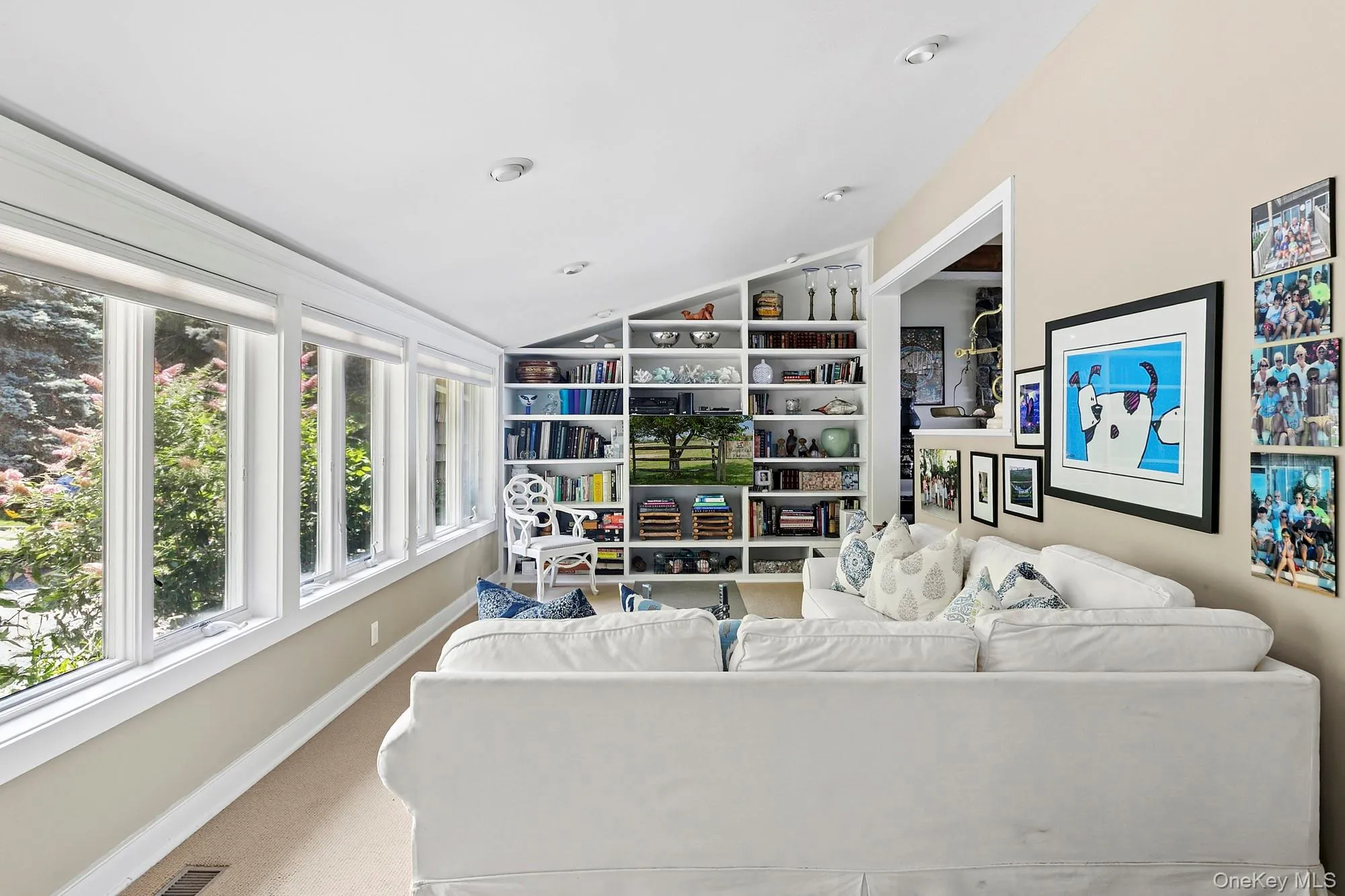 Carpeted living room with vaulted ceiling and baseboards Carpeted living room with vaulted ceiling and baseboards