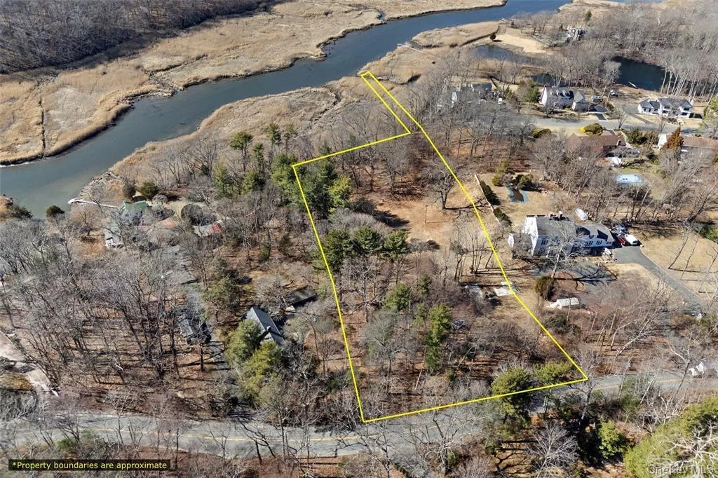Aerial overview of property's location featuring property boundaries highlighted and a large body of water Aerial overview of property's location featuring property boundaries highlighted and a large body of water