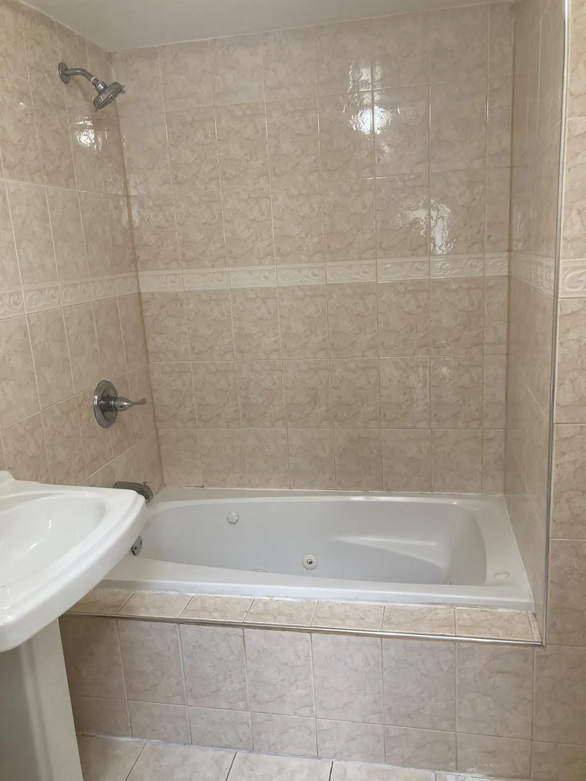 Full bathroom with tiled shower / bath, tile patterned floors, and tile walls Full bathroom with tiled shower / bath, tile patterned floors, and tile walls