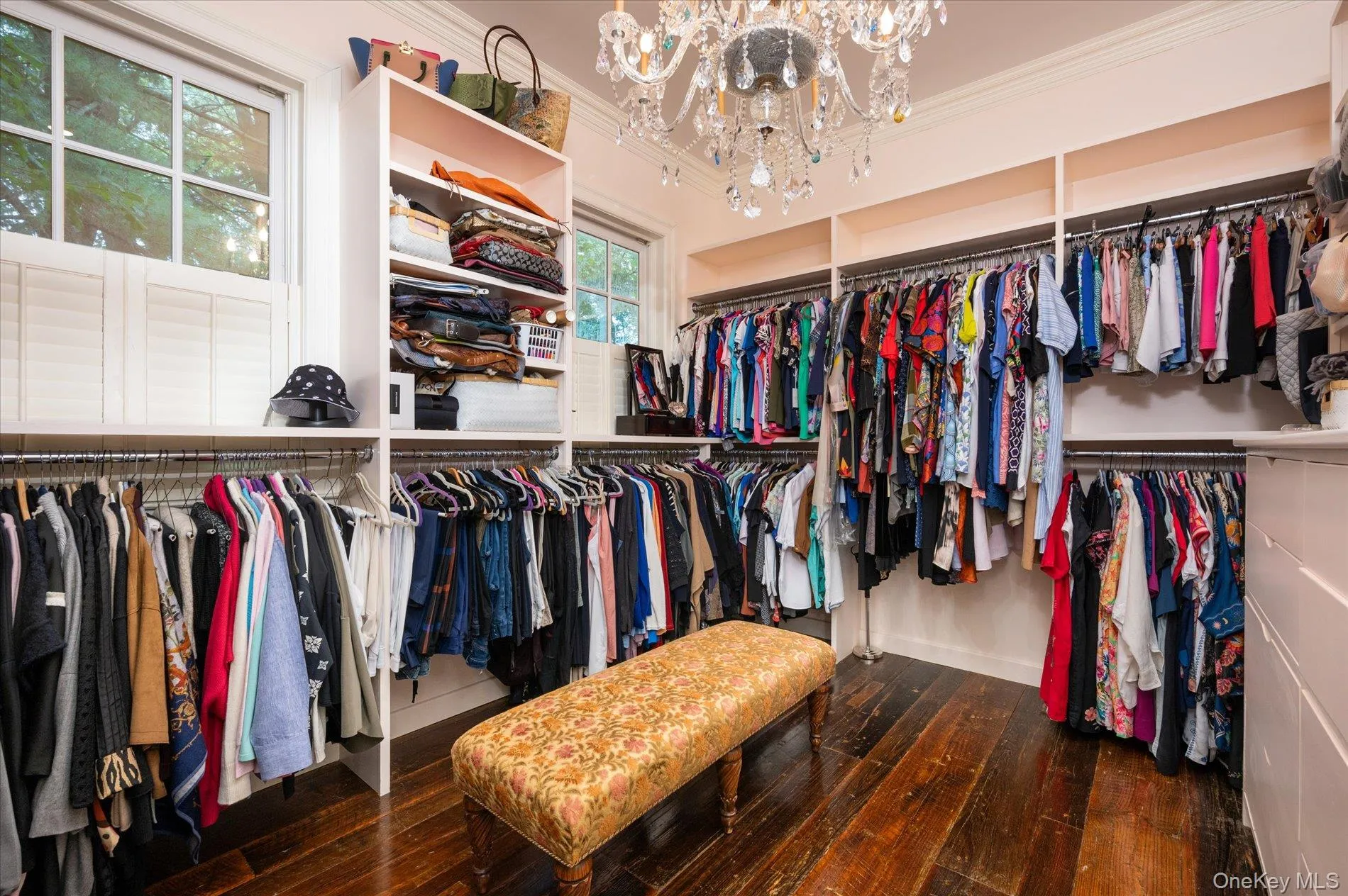 Walk in closet with a chandelier and hardwood / wood-style floors Walk in closet with a chandelier and hardwood / wood-style floors