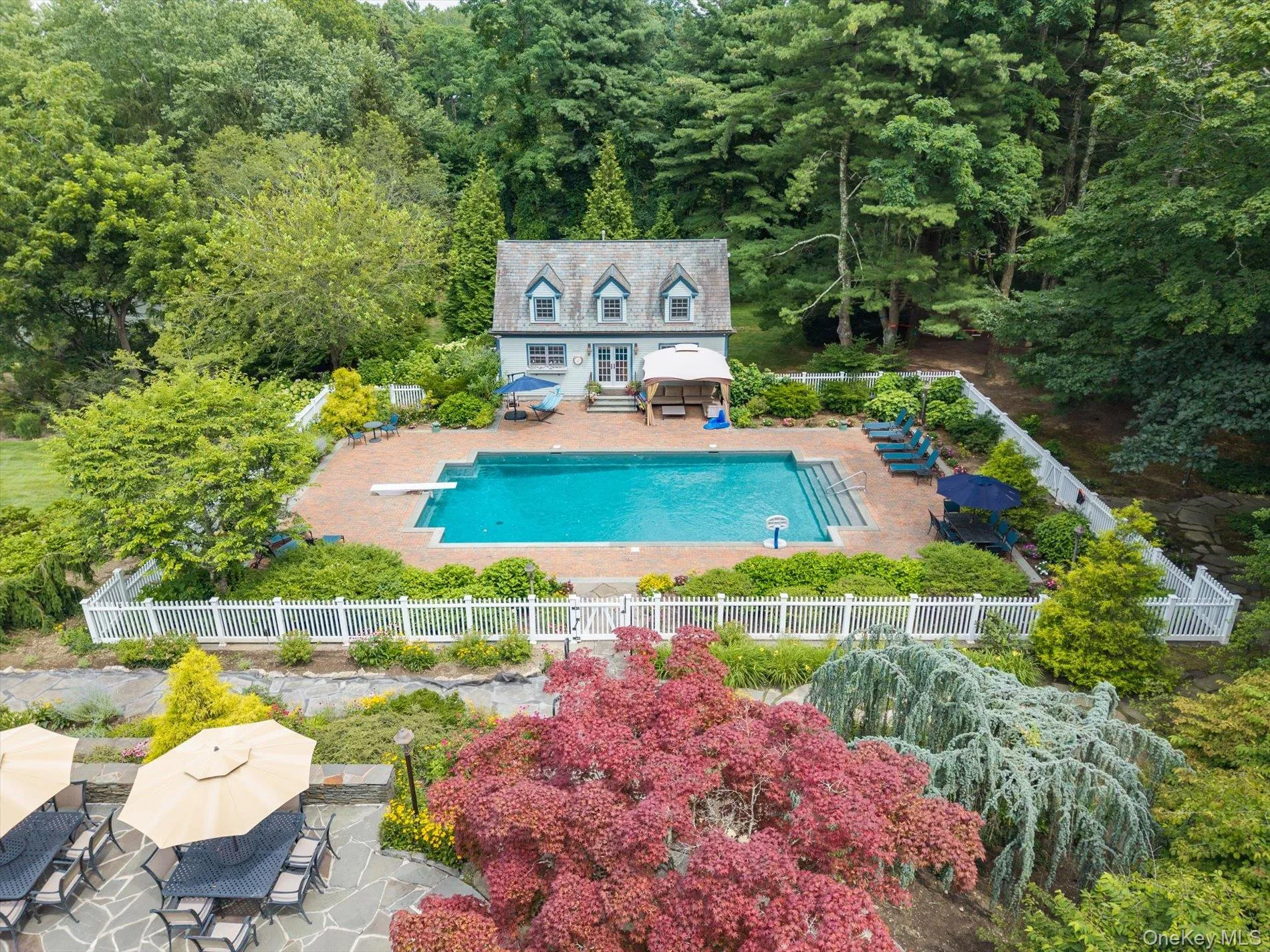 View of swimming pool featuring an exterior structure, an outbuilding, a forest view, a fenced backyard, and a patio View of swimming pool featuring an exterior structure, an outbuilding, a forest view, a fenced backyard, and a patio