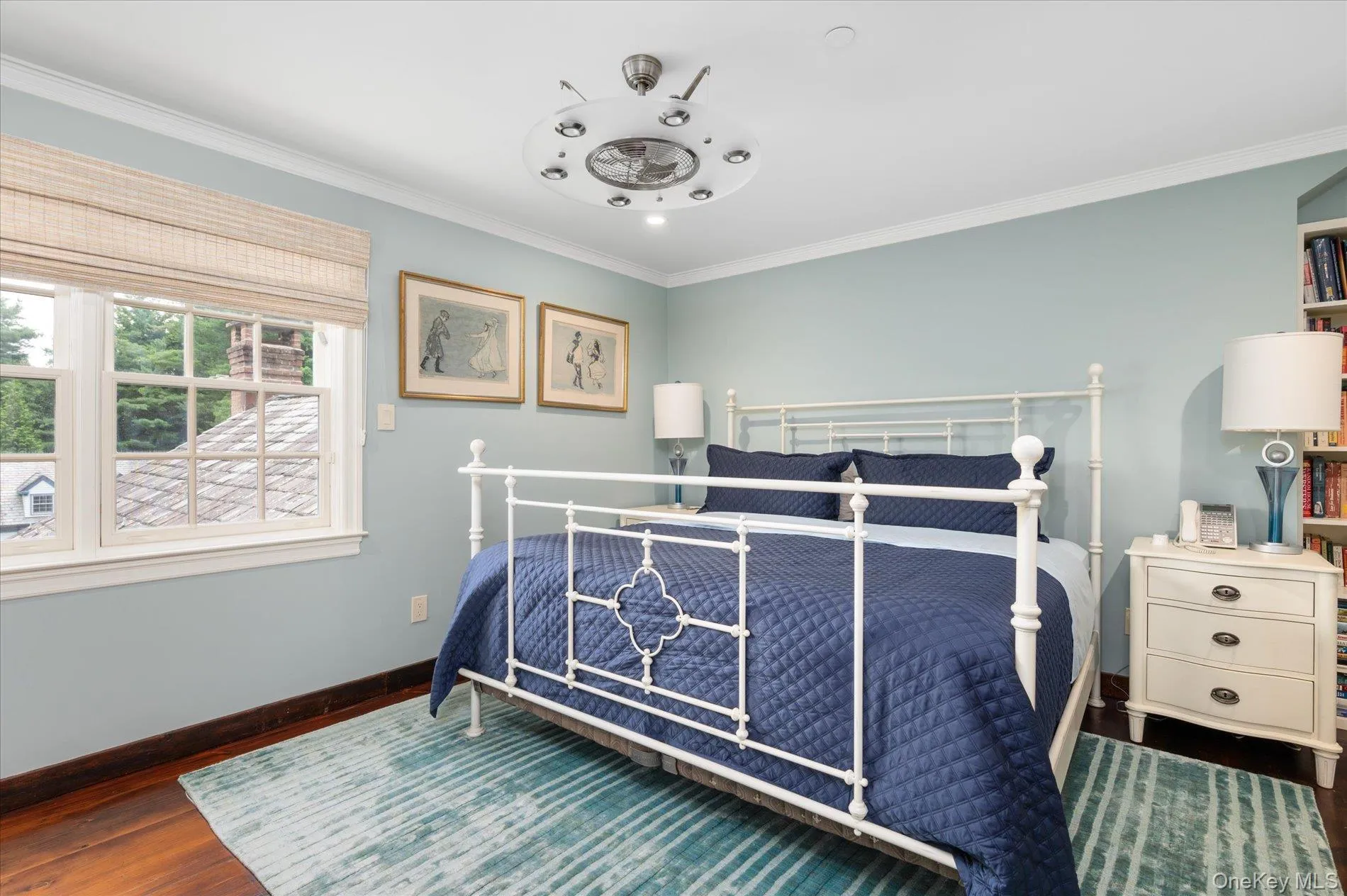 Bedroom with ornamental molding and wood finished floors Bedroom with ornamental molding and wood finished floors