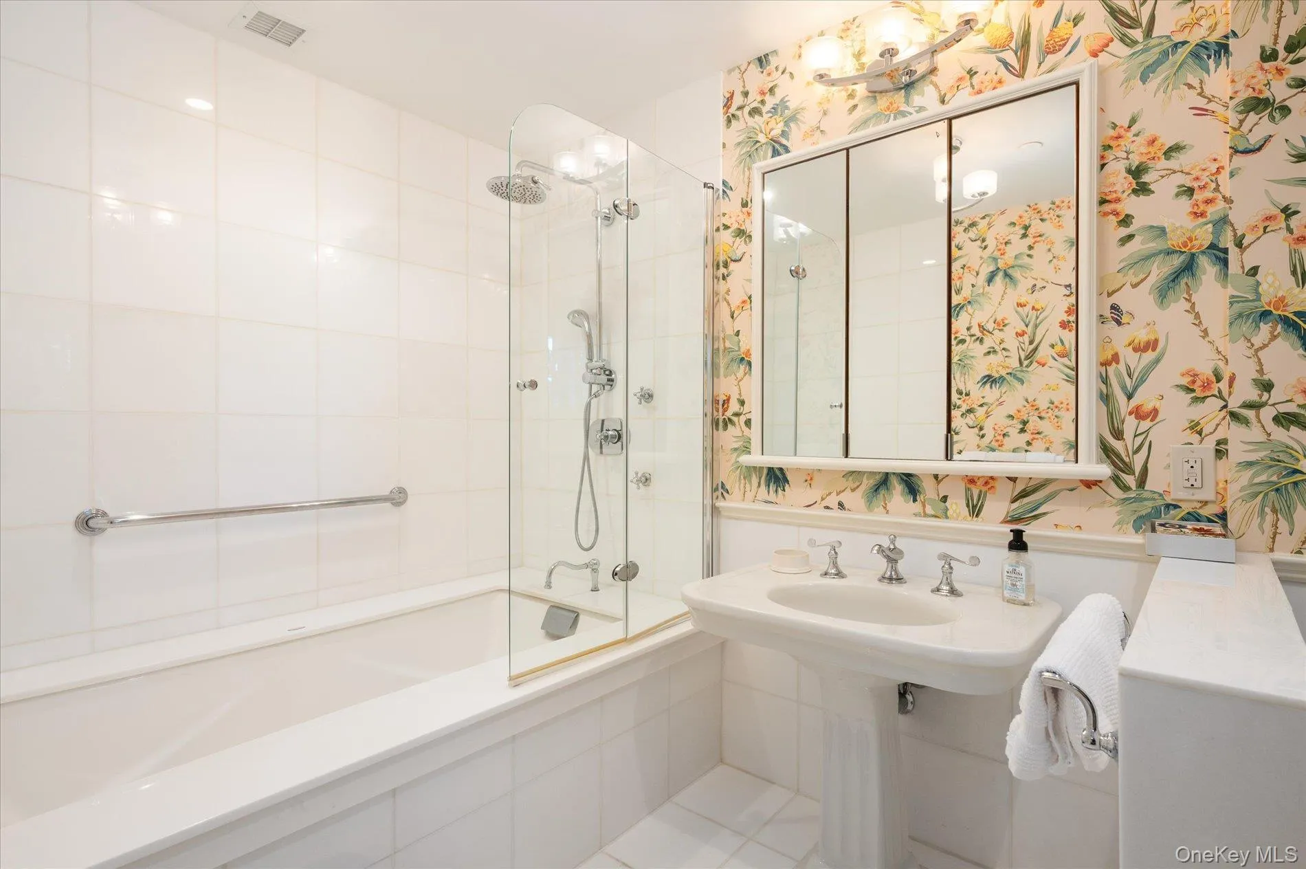 Bathroom with tiled shower / bath and wallpapered walls Bathroom with tiled shower / bath and wallpapered walls