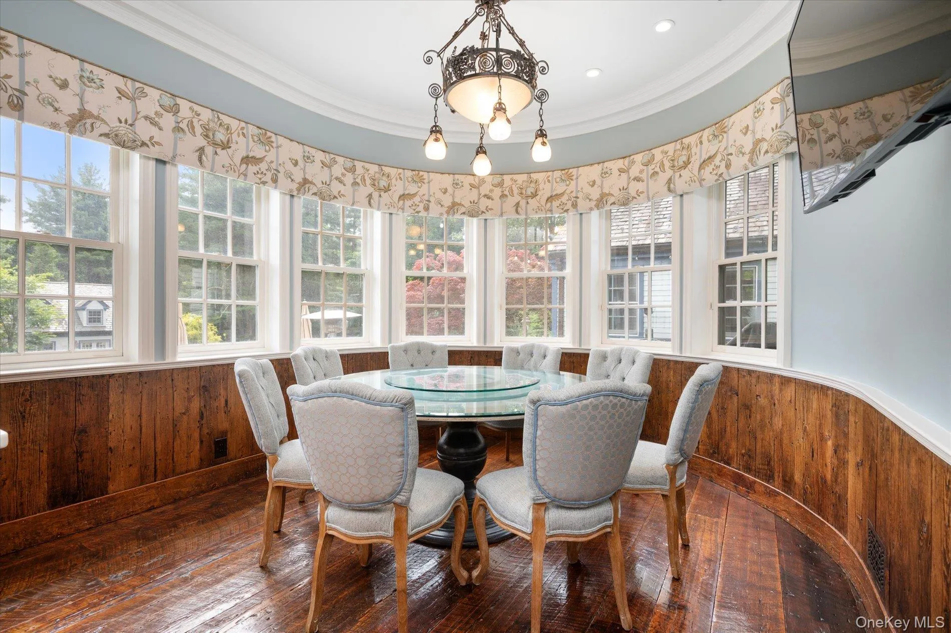 Dining area with wainscoting, wood walls, hardwood / wood-style floors, and ornamental molding Dining area with wainscoting, wood walls, hardwood / wood-style floors, and ornamental molding