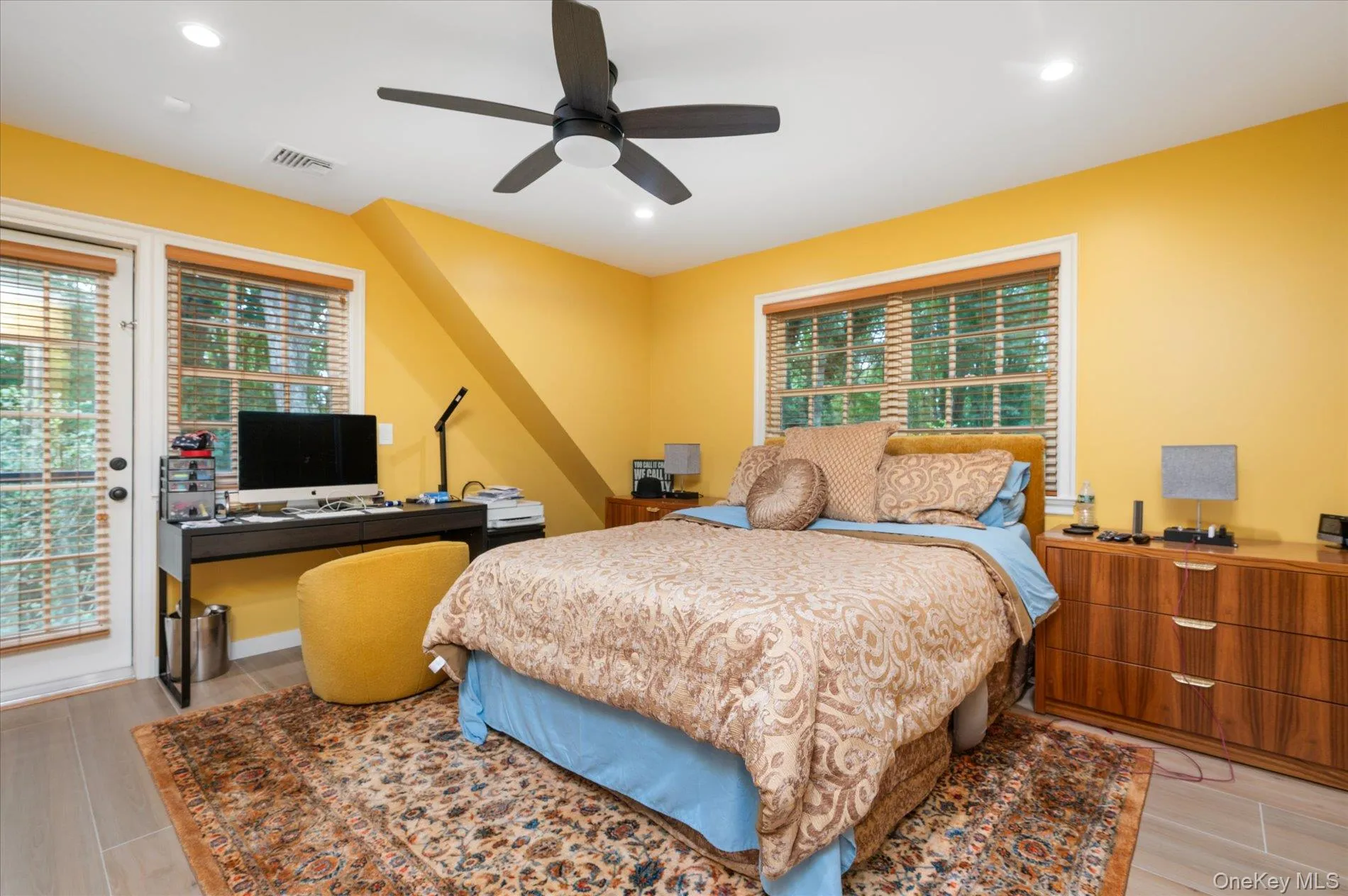 Bedroom featuring multiple windows, wood finish floors, a desk, and recessed lighting Bedroom featuring multiple windows, wood finish floors, a desk, and recessed lighting