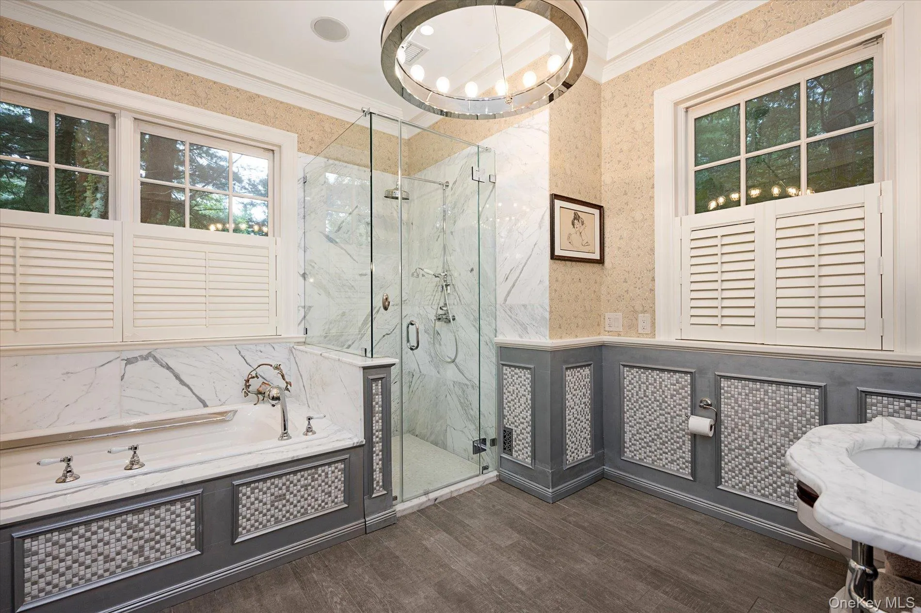 Full bath with wallpapered walls, a wainscoted wall, a garden tub, crown molding, and a marble finish shower Full bath with wallpapered walls, a wainscoted wall, a garden tub, crown molding, and a marble finish shower