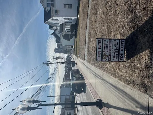 View of asphalt road featuring a residential view, sidewalks, curbs, and street lights View of asphalt road featuring a residential view, sidewalks, curbs, and street lights