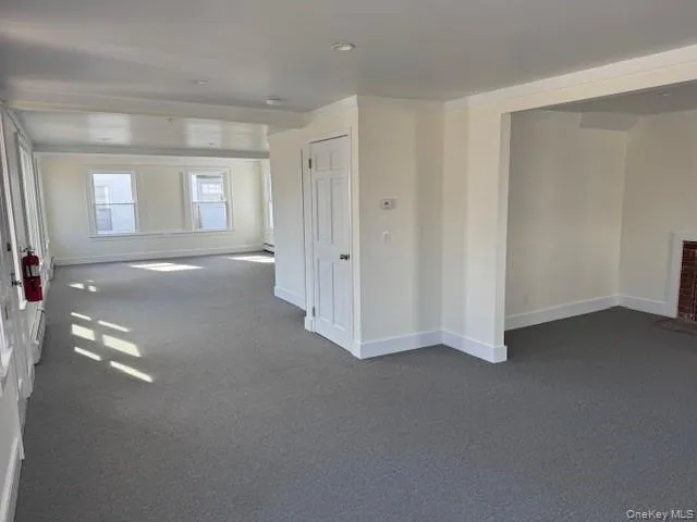 Spare room featuring dark carpet and ornamental molding Spare room featuring dark carpet and ornamental molding