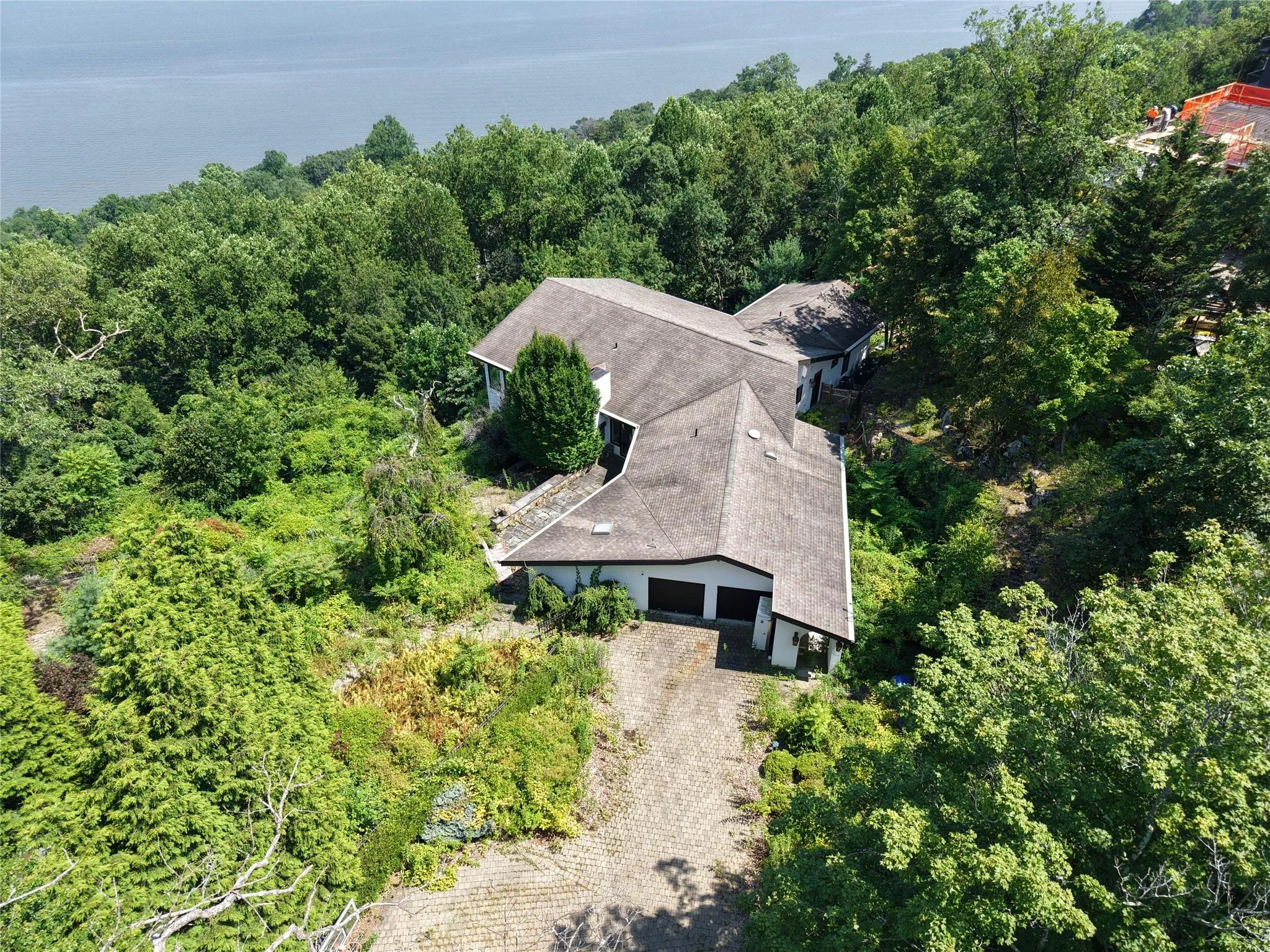 Aerial view of property and surrounding area featuring a forest and a nearby body of water Aerial view of property and surrounding area featuring a forest and a nearby body of water