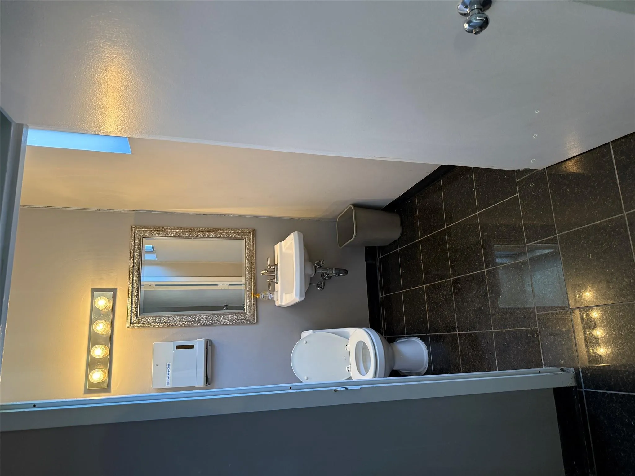 Bathroom featuring toilet and granite tiled floors Bathroom featuring toilet and granite tiled floors
