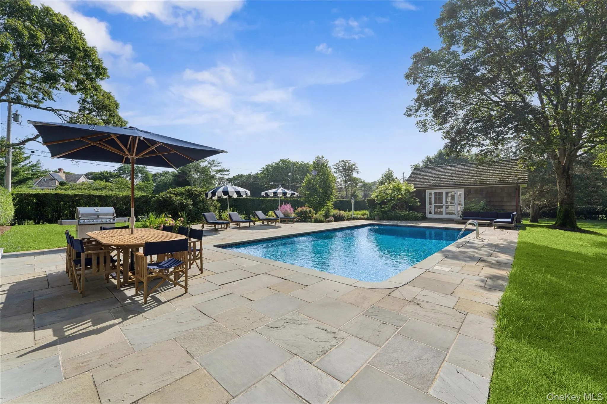 Swimming pool featuring a patio area, a storage structure, outdoor dining space, an outdoor structure, and grilling area Swimming pool featuring a patio area, a storage structure, outdoor dining space, an outdoor structure, and grilling area