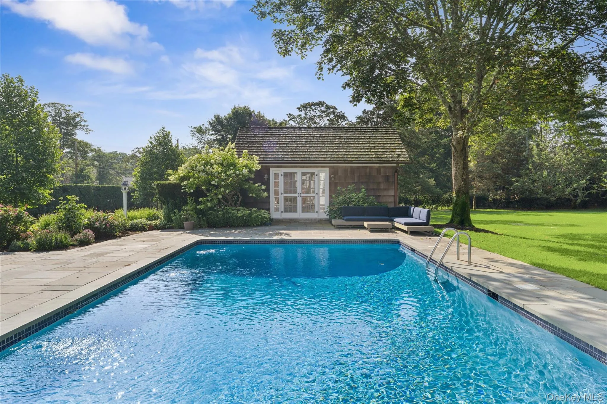 Outdoor pool with an exterior structure, an outdoor hangout area, a yard, an outbuilding, and a patio area Outdoor pool with an exterior structure, an outdoor hangout area, a yard, an outbuilding, and a patio area