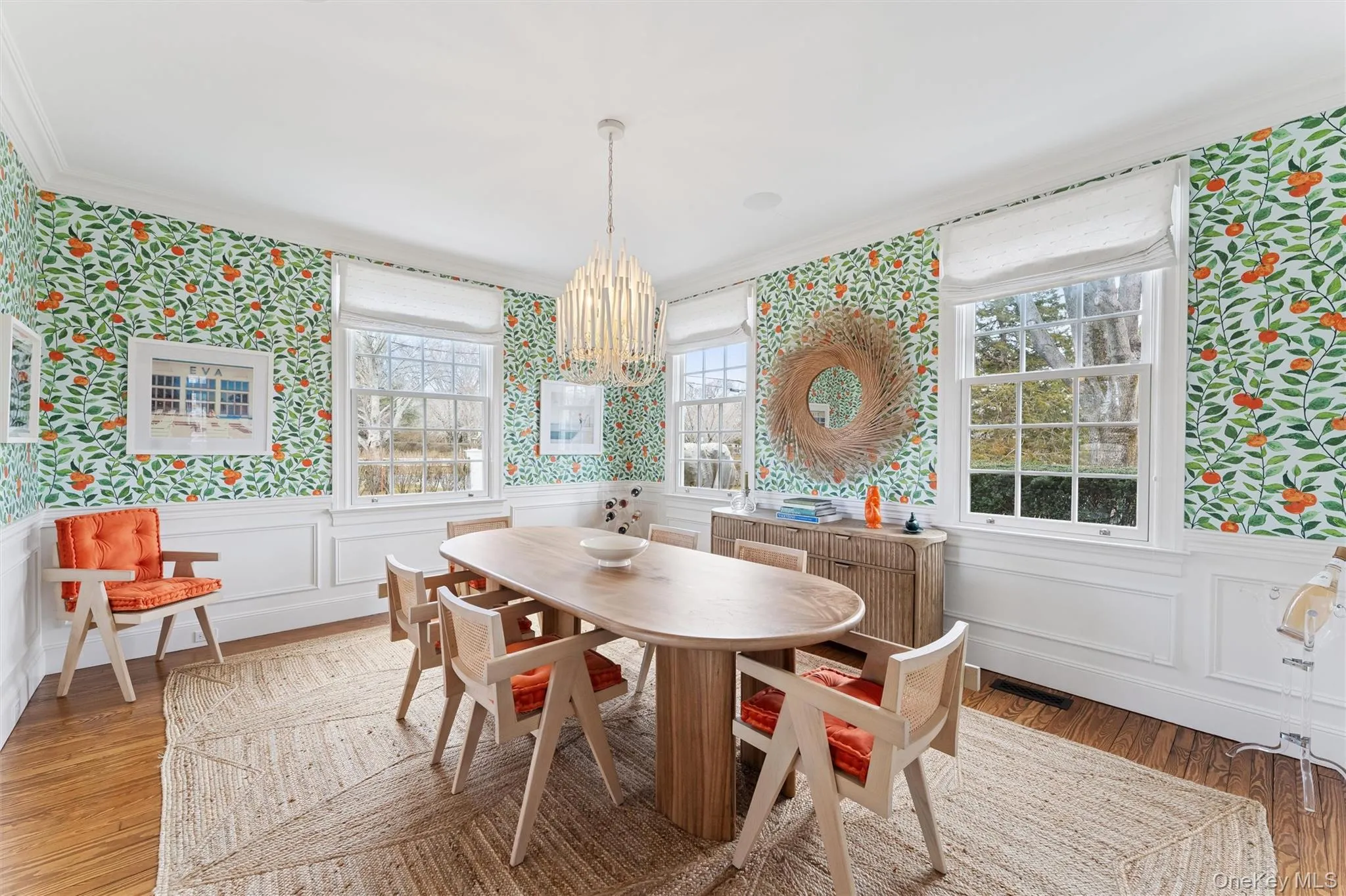 Dining area with wallpapered walls, an inviting chandelier, a wainscoted wall, and light wood-type flooring Dining area with wallpapered walls, an inviting chandelier, a wainscoted wall, and light wood-type flooring