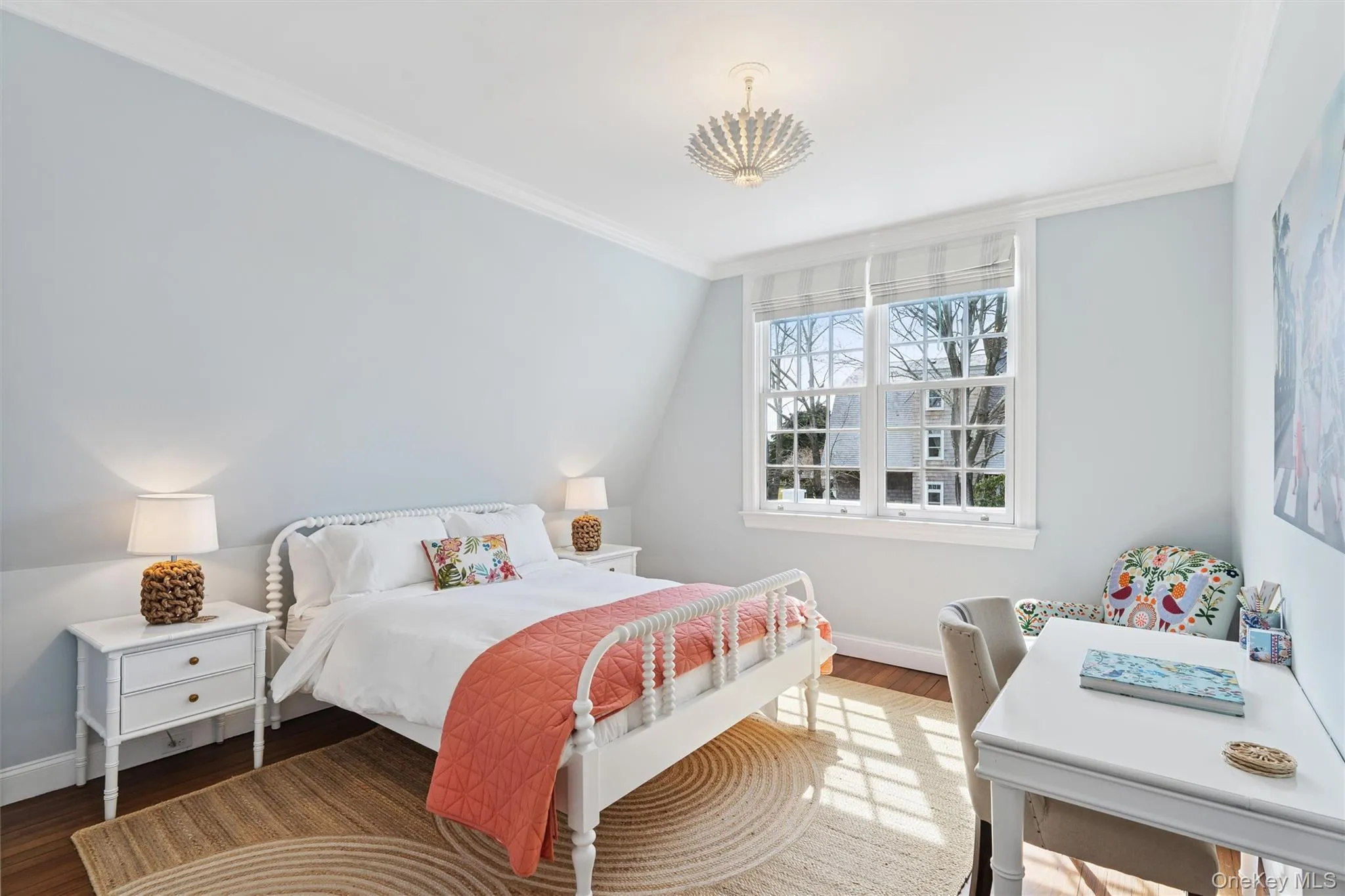 Bedroom featuring baseboards, wood finished floors, and crown molding Bedroom featuring baseboards, wood finished floors, and crown molding