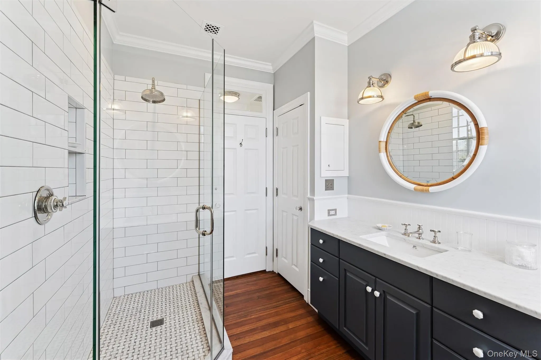 Bathroom with vanity, crown molding, wood finished floors, and a stall shower Bathroom with vanity, crown molding, wood finished floors, and a stall shower