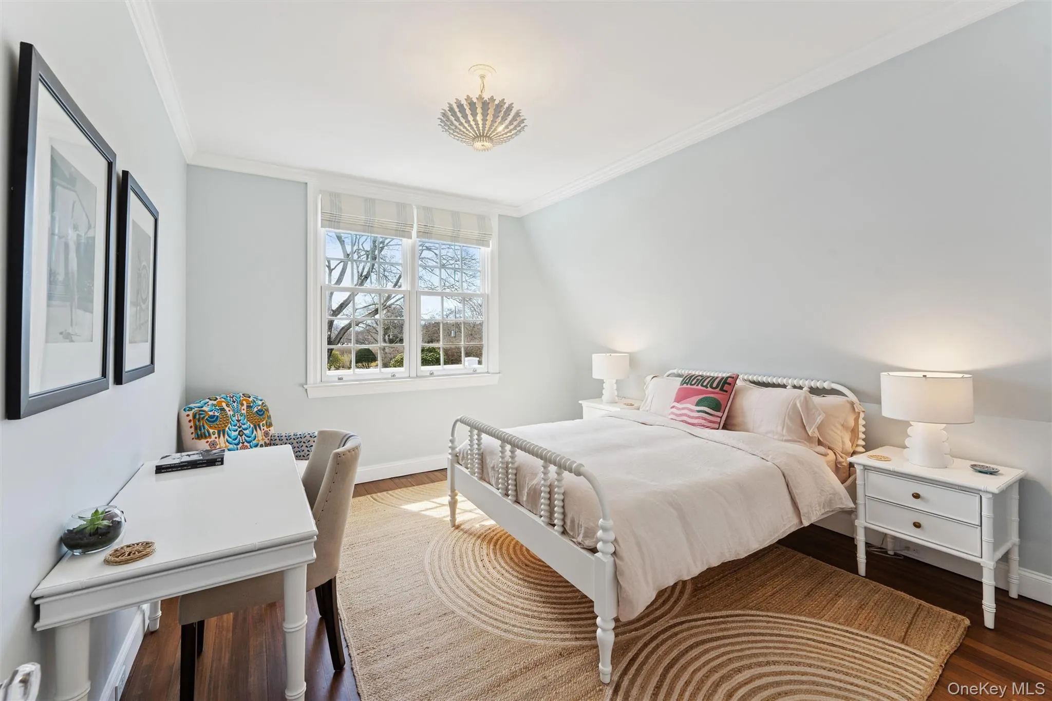Bedroom featuring crown molding, wood finished floors, and baseboards Bedroom featuring crown molding, wood finished floors, and baseboards