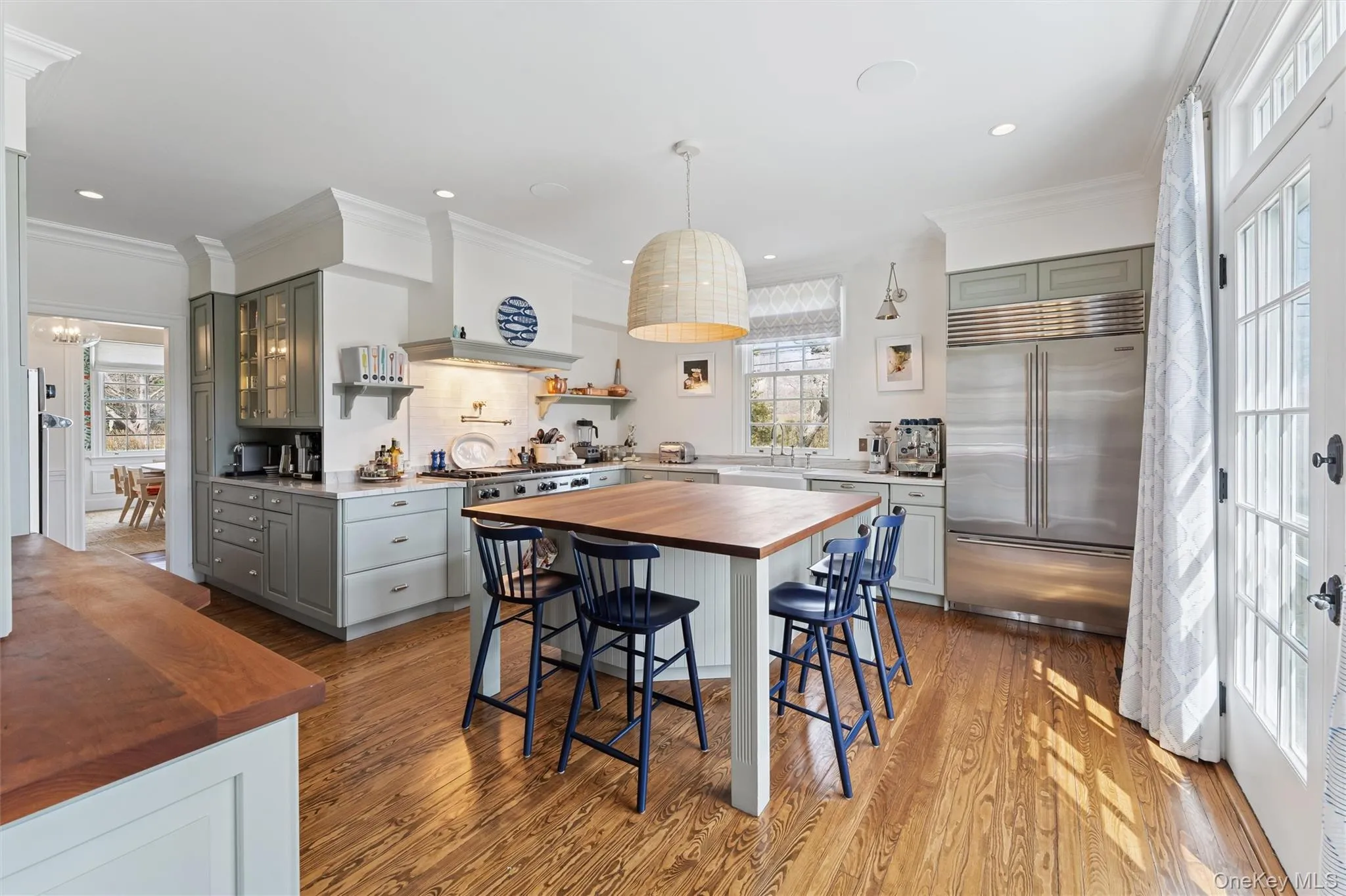 Kitchen featuring gray cabinets, light wood-style floors, wood counters, tasteful backsplash, and stainless steel built in refrigerator Kitchen featuring gray cabinets, light wood-style floors, wood counters, tasteful backsplash, and stainless steel built in refrigerator