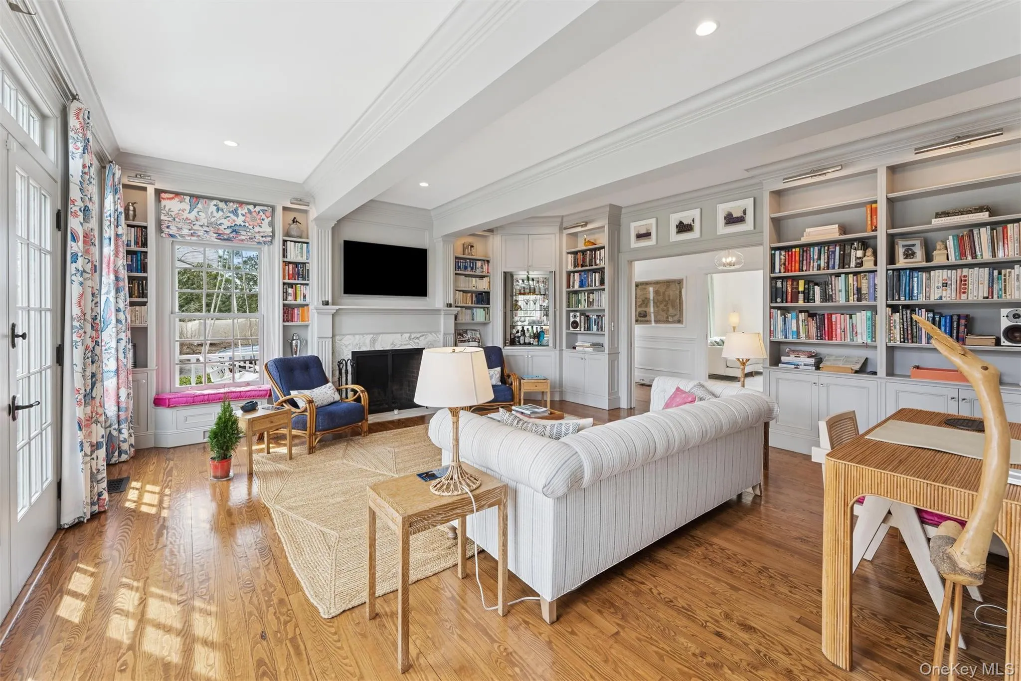 Living room with crown molding, recessed lighting, wood finished floors, and a premium fireplace Living room with crown molding, recessed lighting, wood finished floors, and a premium fireplace