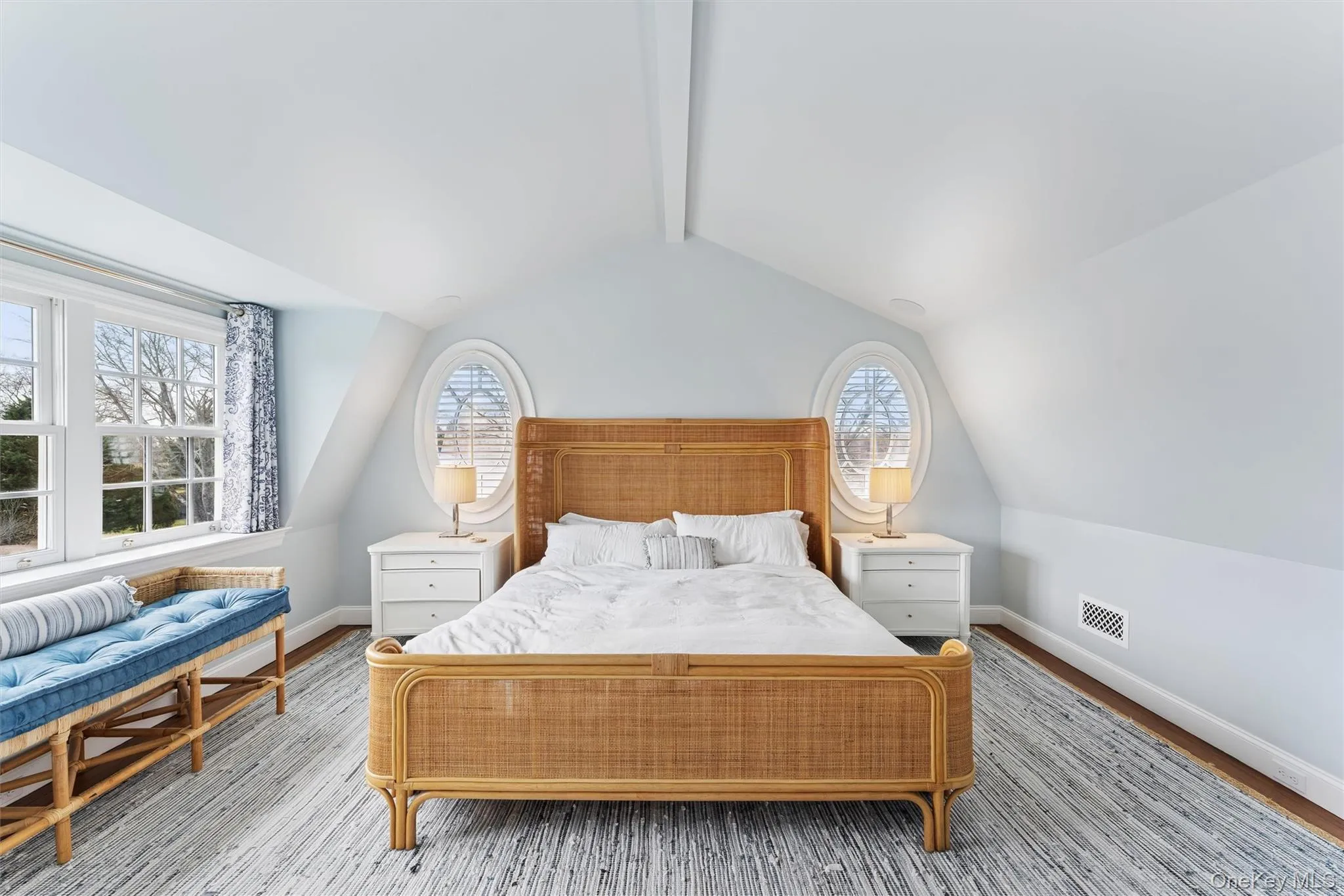 Bedroom featuring lofted ceiling with beams, wood finished floors, visible vents, and baseboards Bedroom featuring lofted ceiling with beams, wood finished floors, visible vents, and baseboards