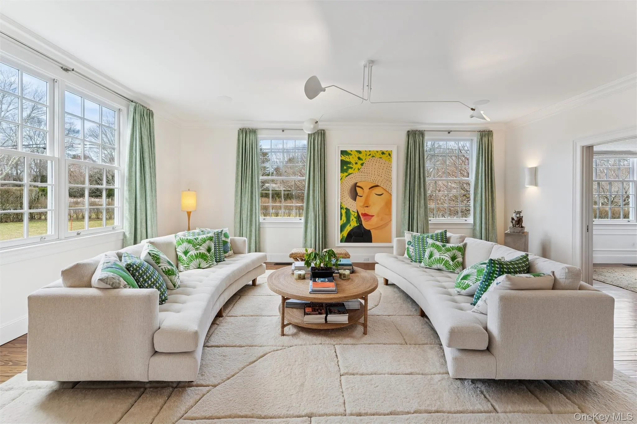 Living room with a wealth of natural light, baseboards, wood finished floors, and crown molding Living room with a wealth of natural light, baseboards, wood finished floors, and crown molding