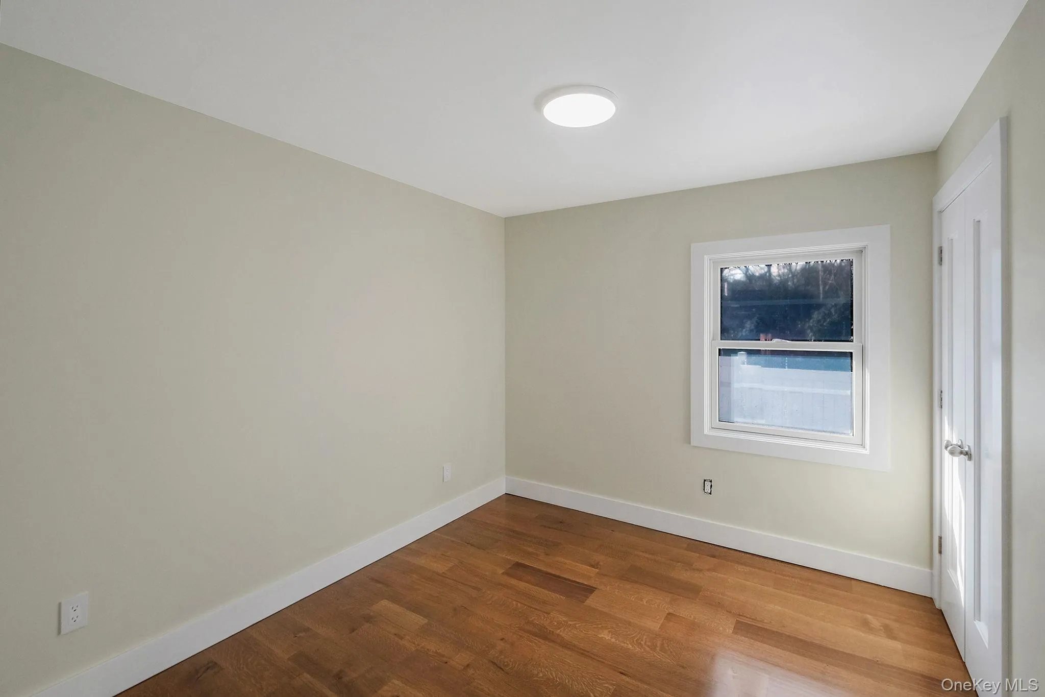 Spare room featuring wood finished floors and baseboards Spare room featuring wood finished floors and baseboards