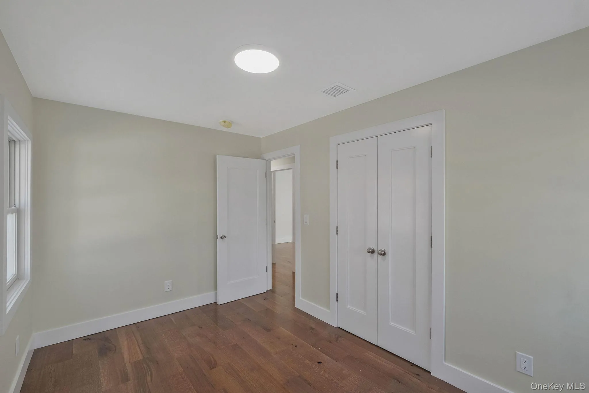 Unfurnished bedroom with wood finished floors and a closet Unfurnished bedroom with wood finished floors and a closet