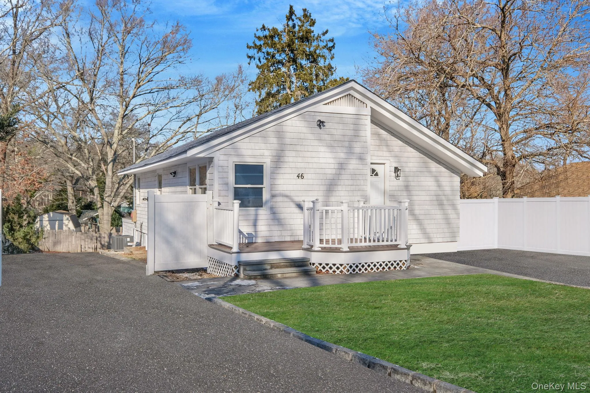 View of front facade with a wooden deck and asphalt driveway View of front facade with a wooden deck and asphalt driveway