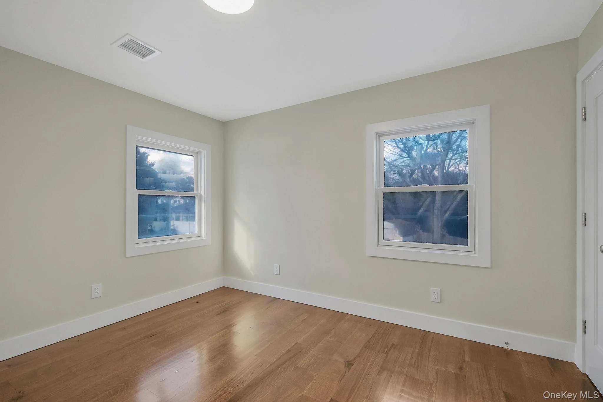 Empty room with baseboards and wood finished floors Empty room with baseboards and wood finished floors