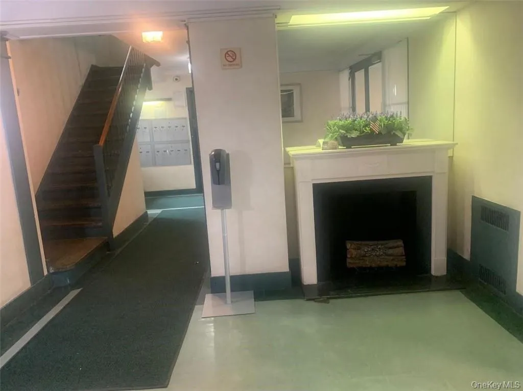 Hall with finished concrete flooring, radiator heating unit, and stairs Hall with finished concrete flooring, radiator heating unit, and stairs