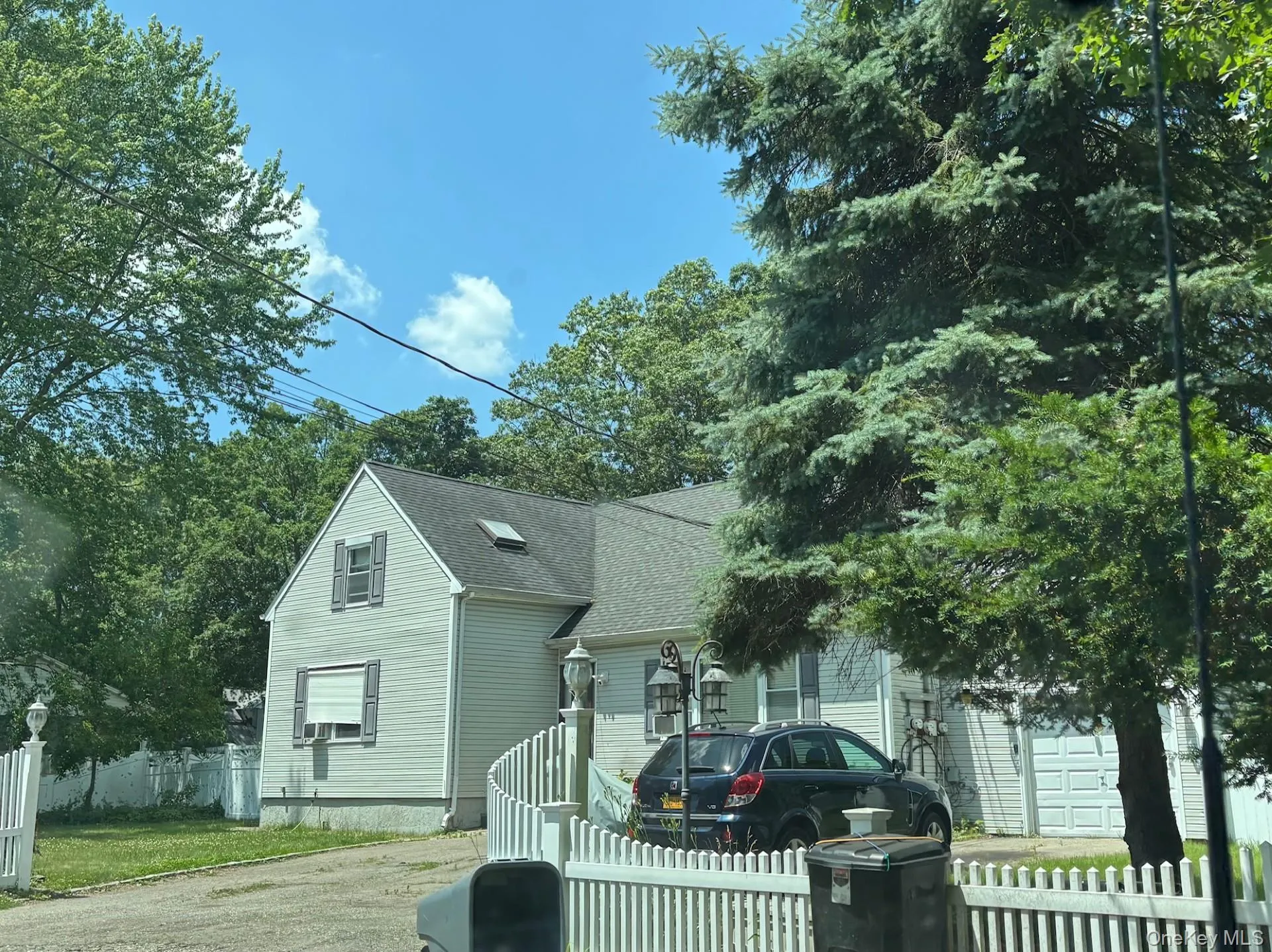 View of front of property featuring a shingled roof and driveway View of front of property featuring a shingled roof and driveway