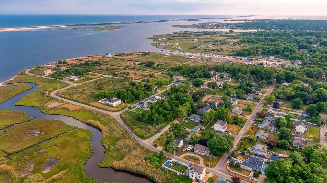 Aerial overview of property's location featuring a nearby body of water and nearby suburban area Aerial overview of property's location featuring a nearby body of water and nearby suburban area