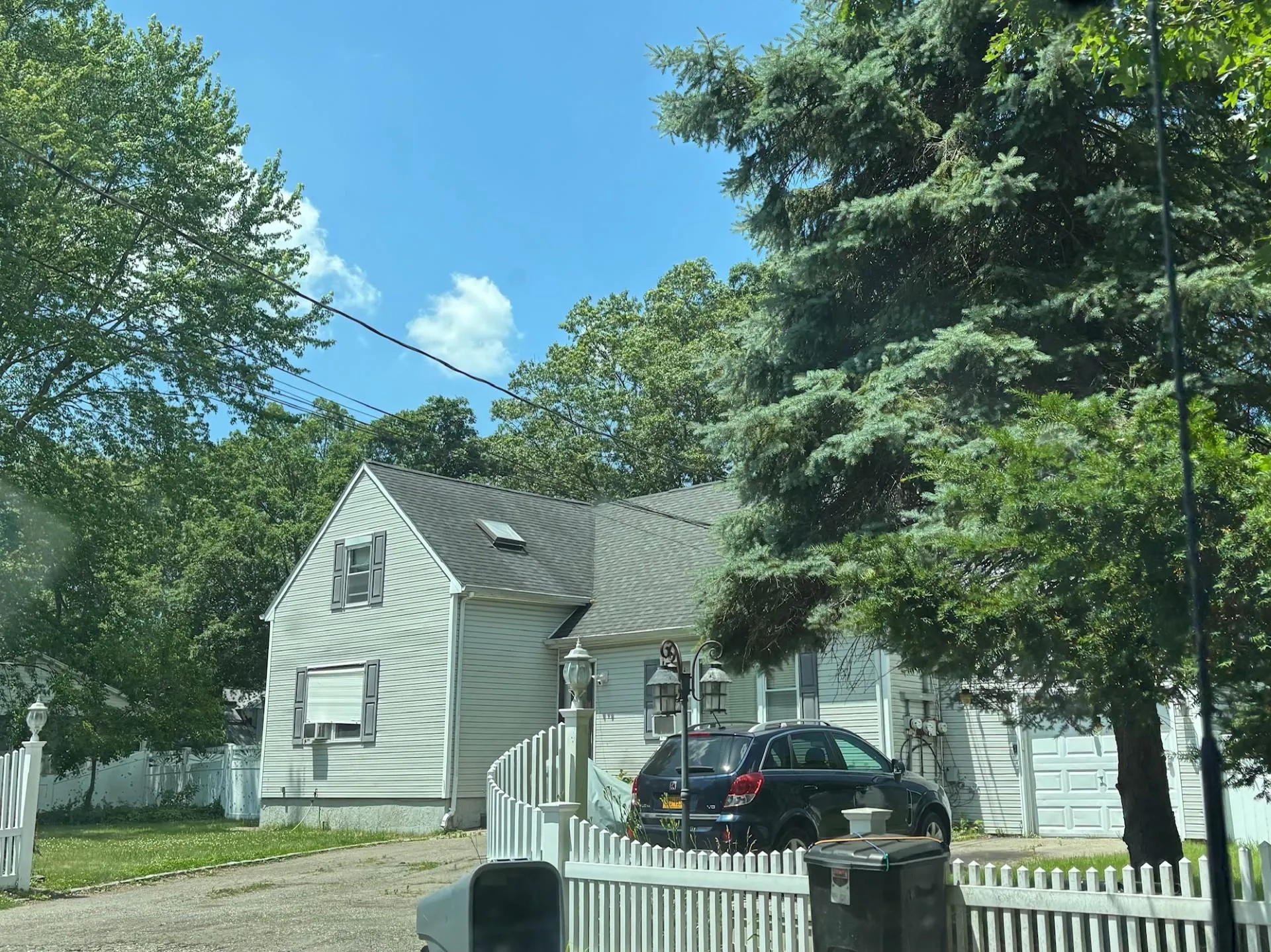 View of front of property featuring a shingled roof and driveway View of front of property featuring a shingled roof and driveway
