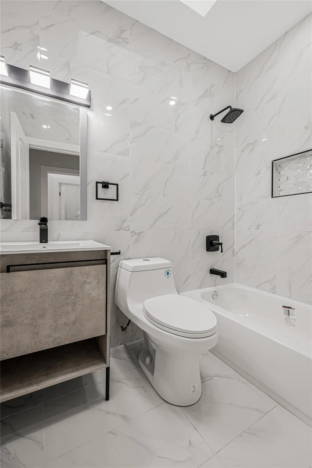 Full bath with marble finish floors, tile walls, vanity, and shower combination Full bath with marble finish floors, tile walls, vanity, and shower combination