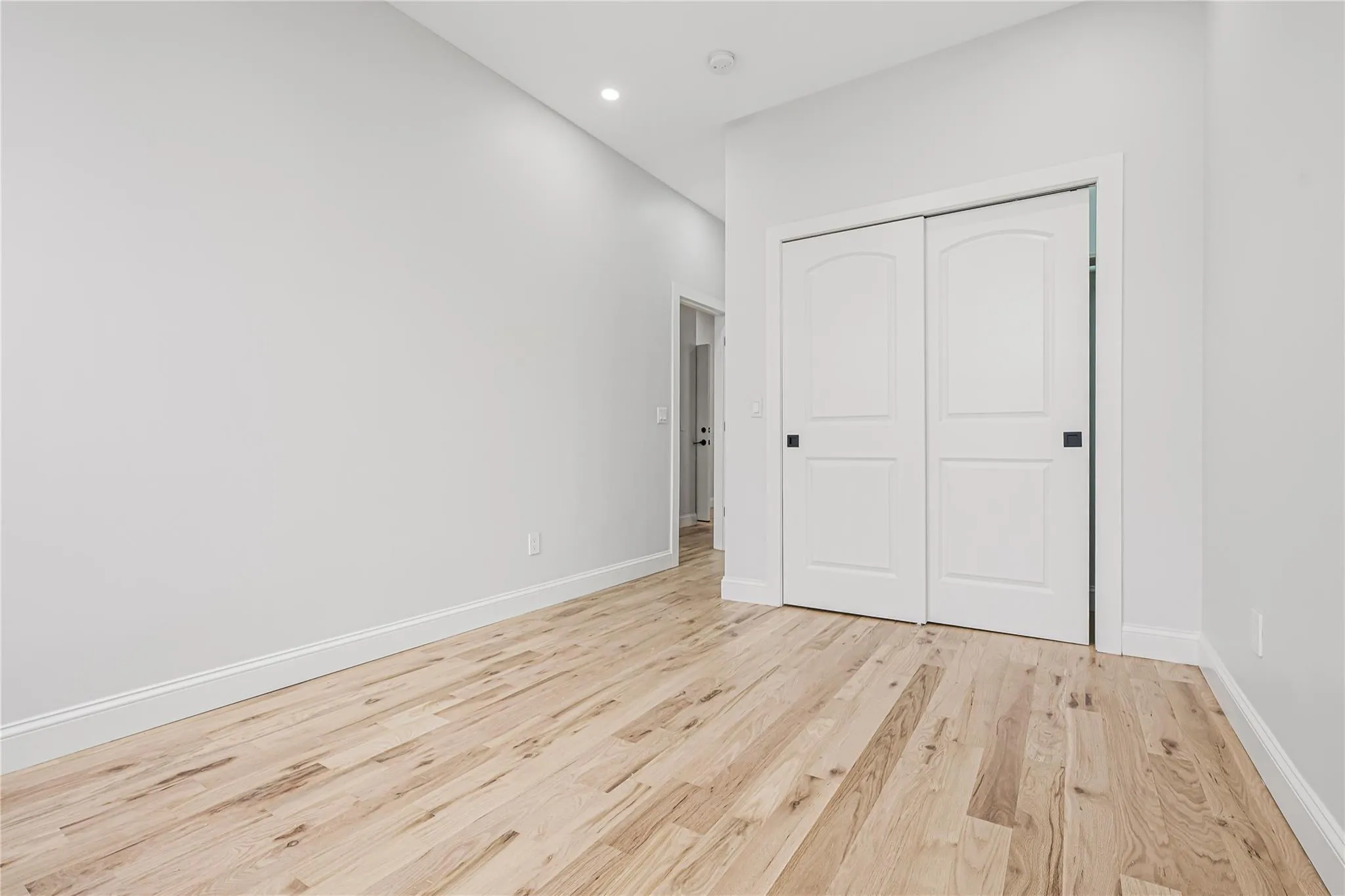 Unfurnished bedroom with light wood finished floors, a closet, and recessed lighting Unfurnished bedroom with light wood finished floors, a closet, and recessed lighting