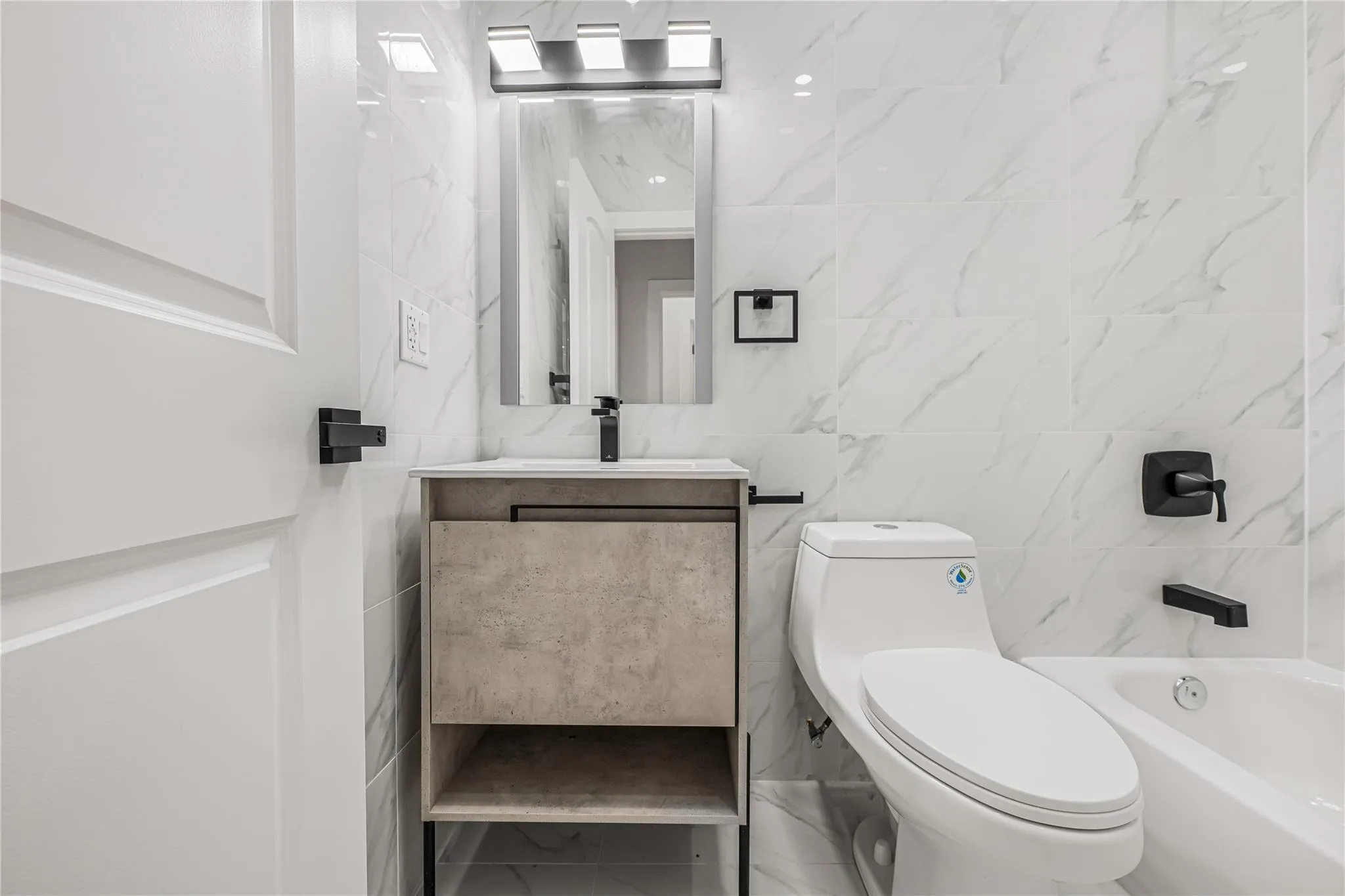 Bathroom featuring tile walls, vanity, and shower combination Bathroom featuring tile walls, vanity, and shower combination