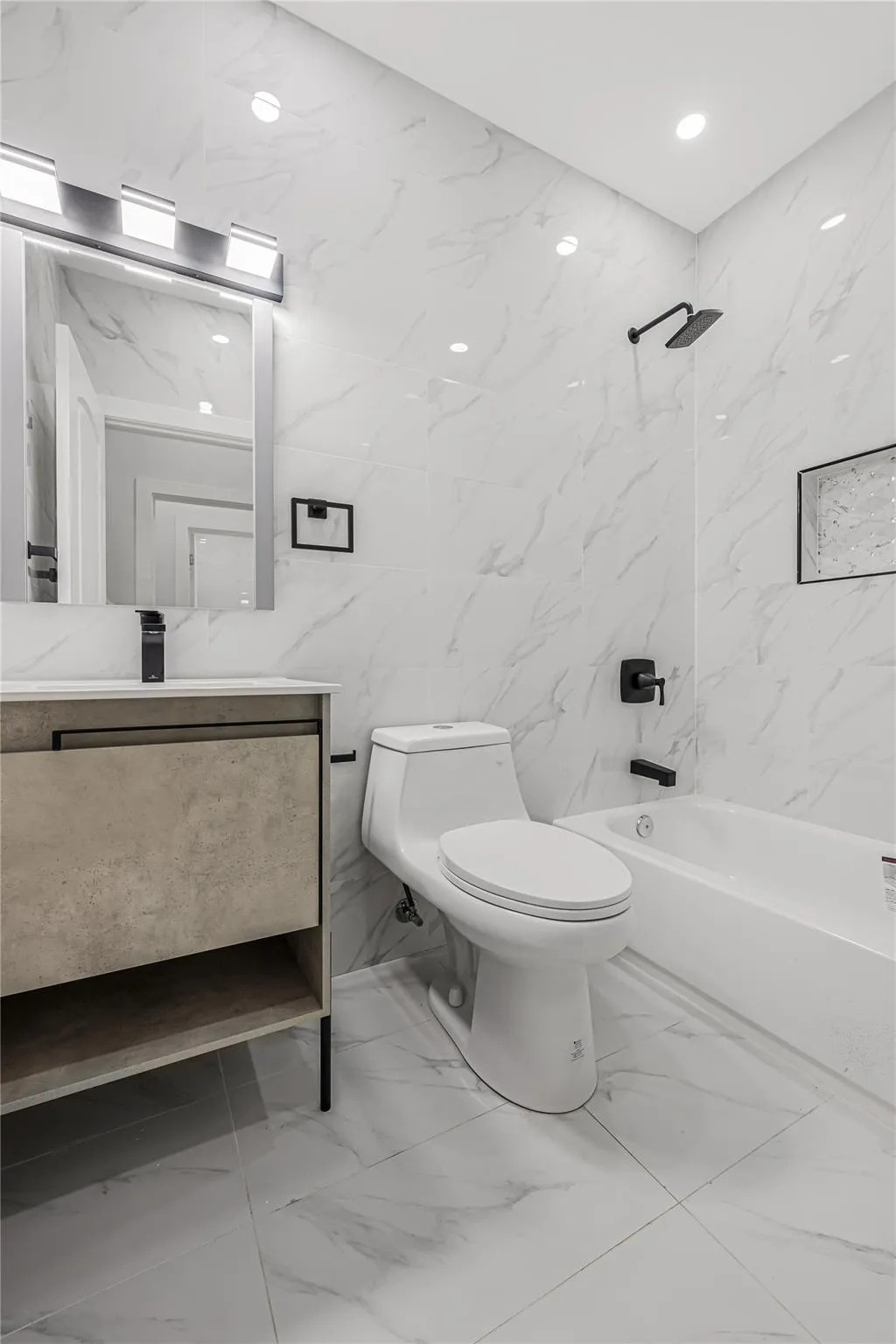 Bathroom with tile walls, vanity, marble finish flooring, and shower combination Bathroom with tile walls, vanity, marble finish flooring, and shower combination