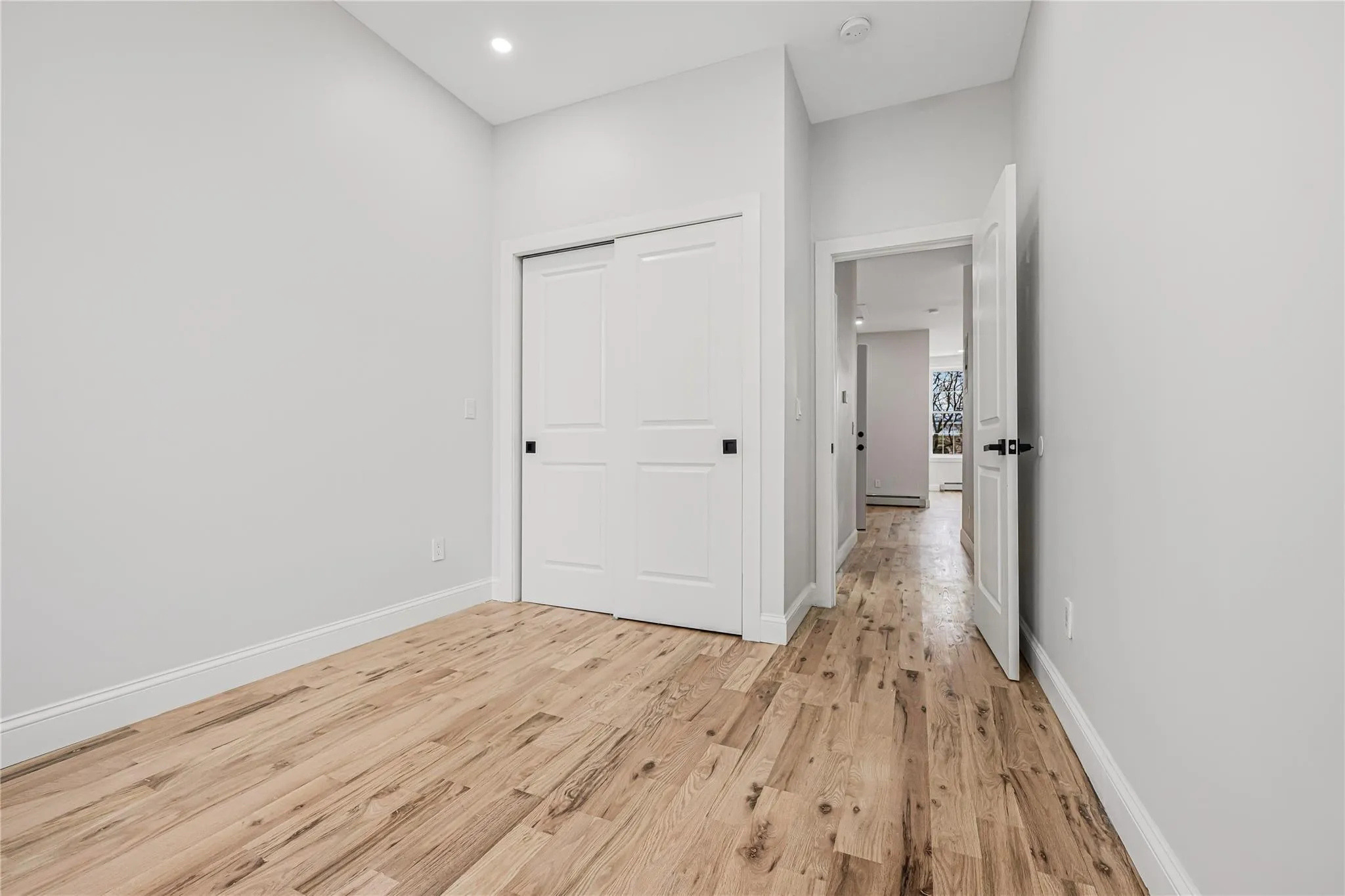 Unfurnished bedroom with light wood finished floors, a closet, and recessed lighting Unfurnished bedroom with light wood finished floors, a closet, and recessed lighting